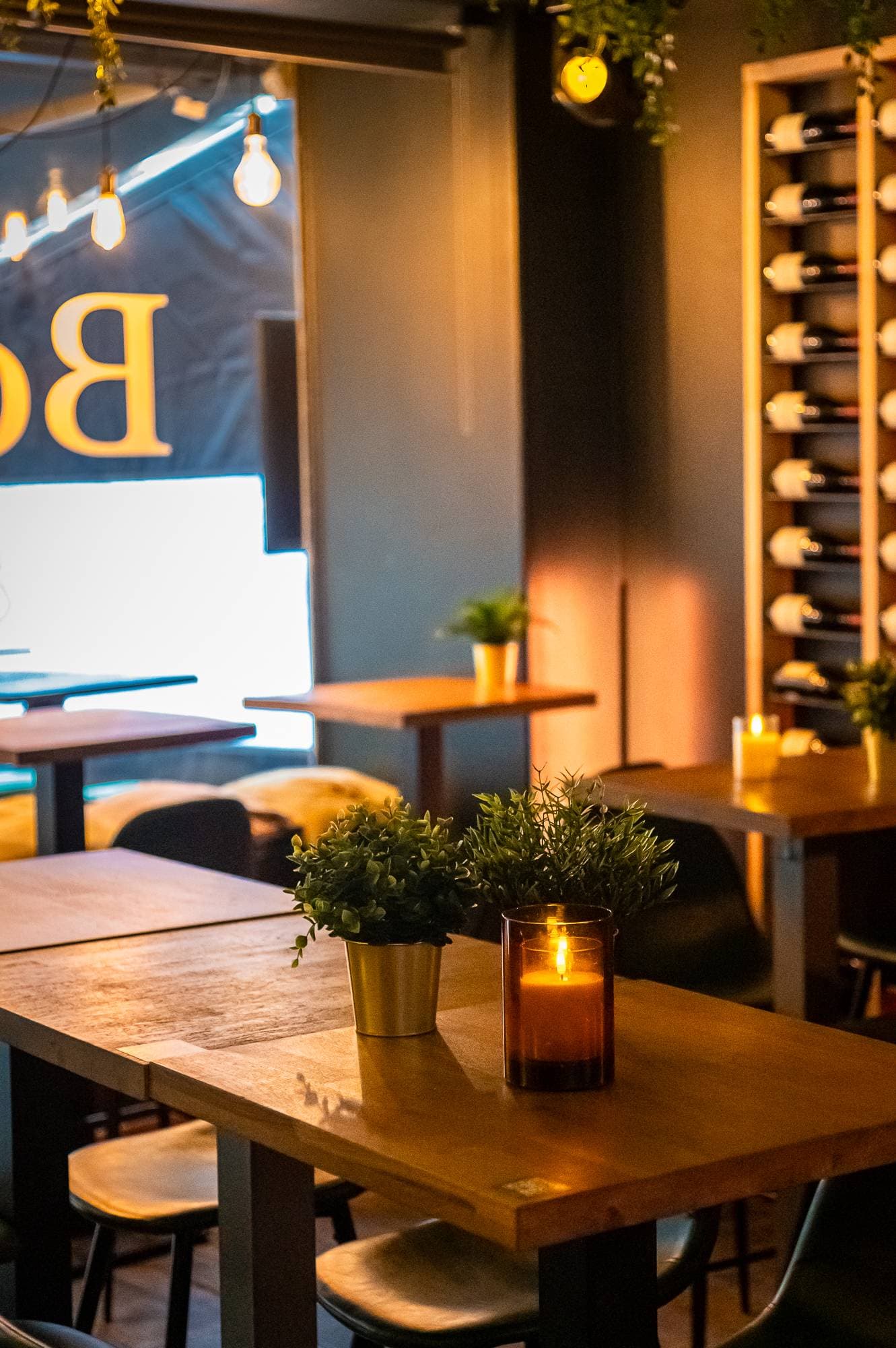 Tables en bois et bougies dans la salle du Bottle Bar