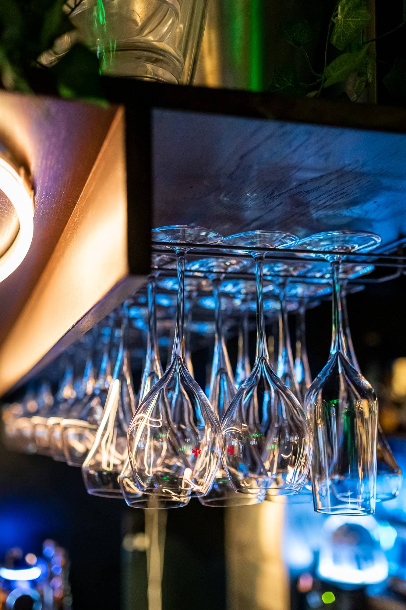 Verres suspendus au-dessus du bar, éclairage bleu